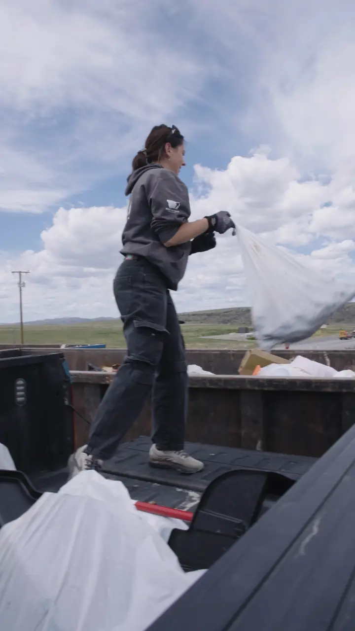 Angelina loading sealed bags into the truck bed